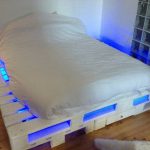 un lit de palettes éclairées en bleu