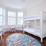 Chambre d'enfant avec un lit en bois blanc sur deux niveaux