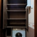 Armoire à l'intérieur avec des étagères avec un espace pour une machine à laver