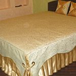 Combinaison de tissu doré et de tissu avec des boucles pour le dessus de lit sur le lit