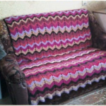 Plaid sur un canapé de restes de fil, reliés par des rayures multicolores en zigzag