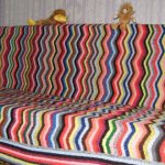 Plaid sur un canapé à partir de bandes ondulées multicolores