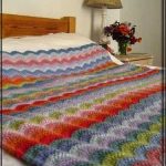 Couverture multicolore à vagues sur un grand lit