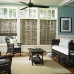 Meubles en rotin dans le salon avec des rideaux de bambou