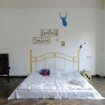 Matelas sur le sol avec des bylets peints pour la décoration dans une chambre meublée de façon minimale
