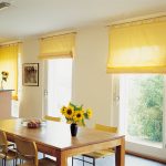 Rideaux enroulés en jaune sur la cuisine avec fixation à l'avant-toit