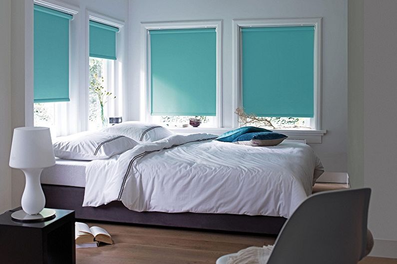 Rideaux turquoise en tissu épais aux fenêtres de la chambre à coucher
