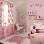 Rideaux avec un motif et un fond rose dans la chambre des filles
