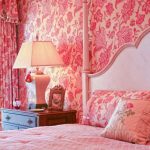 Chambre avec papier peint et rideaux de couleur rose, complétée par un motif floral