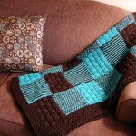 Plaid marron avec des aiguilles à tricoter bleues à partir de carrés