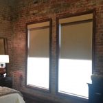 Les rideaux opaques se fondent à l'intérieur d'une chambre de style loft