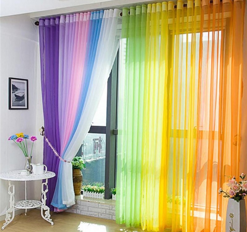 Rideau multicolore sur la fenêtre de la chambre avec balcon