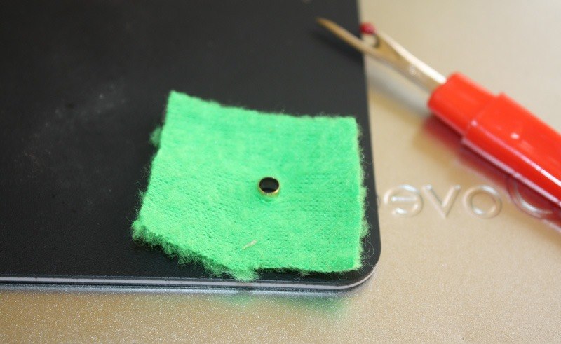 Exemple de montage de l'oeillet sur un morceau de tissu vert