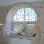 Fenêtre cintrée avec des rideaux dans la salle de bain