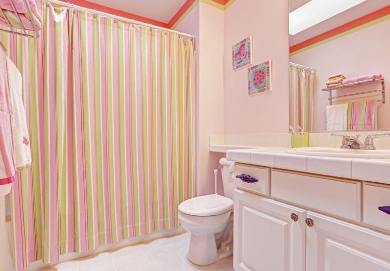 Rideau à rayures dans la salle de bain aux murs roses