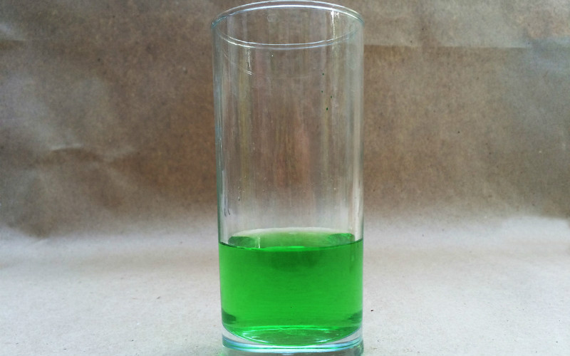 Coupe en verre avec une solution de vert brillant pour le lavage